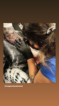 a woman is getting a tattoo on her arm