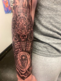 an egyptian tattoo on a man's forearm