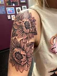 a woman with a sunflower tattoo on her arm