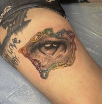 a tattoo of an eye with a chain around it