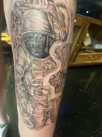 a tattoo of an astronaut on a person's thigh