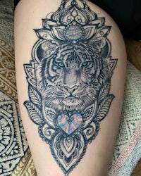a tiger tattoo on a woman's thigh