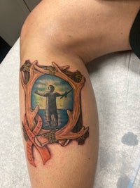 a tattoo of a man with a picture of a moose on his leg
